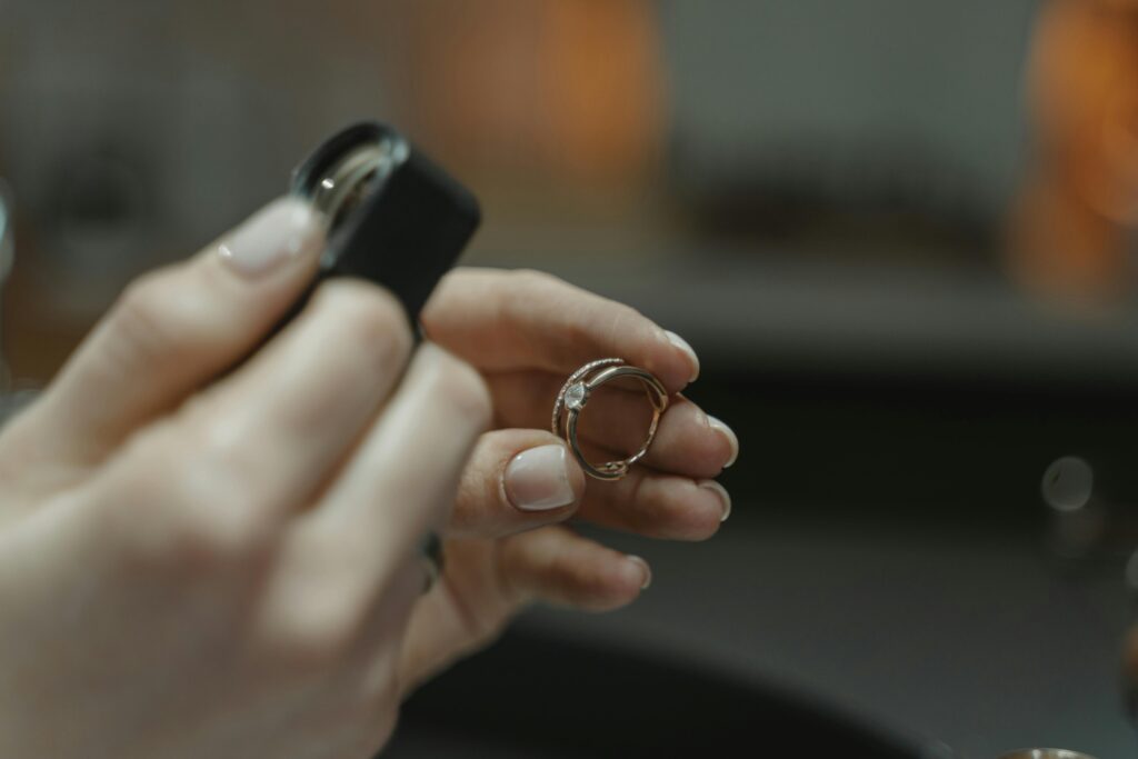 pexels photo 6263113 6263113 Close-up of a jeweler's hands holding a diamond ring and magnifying glass.